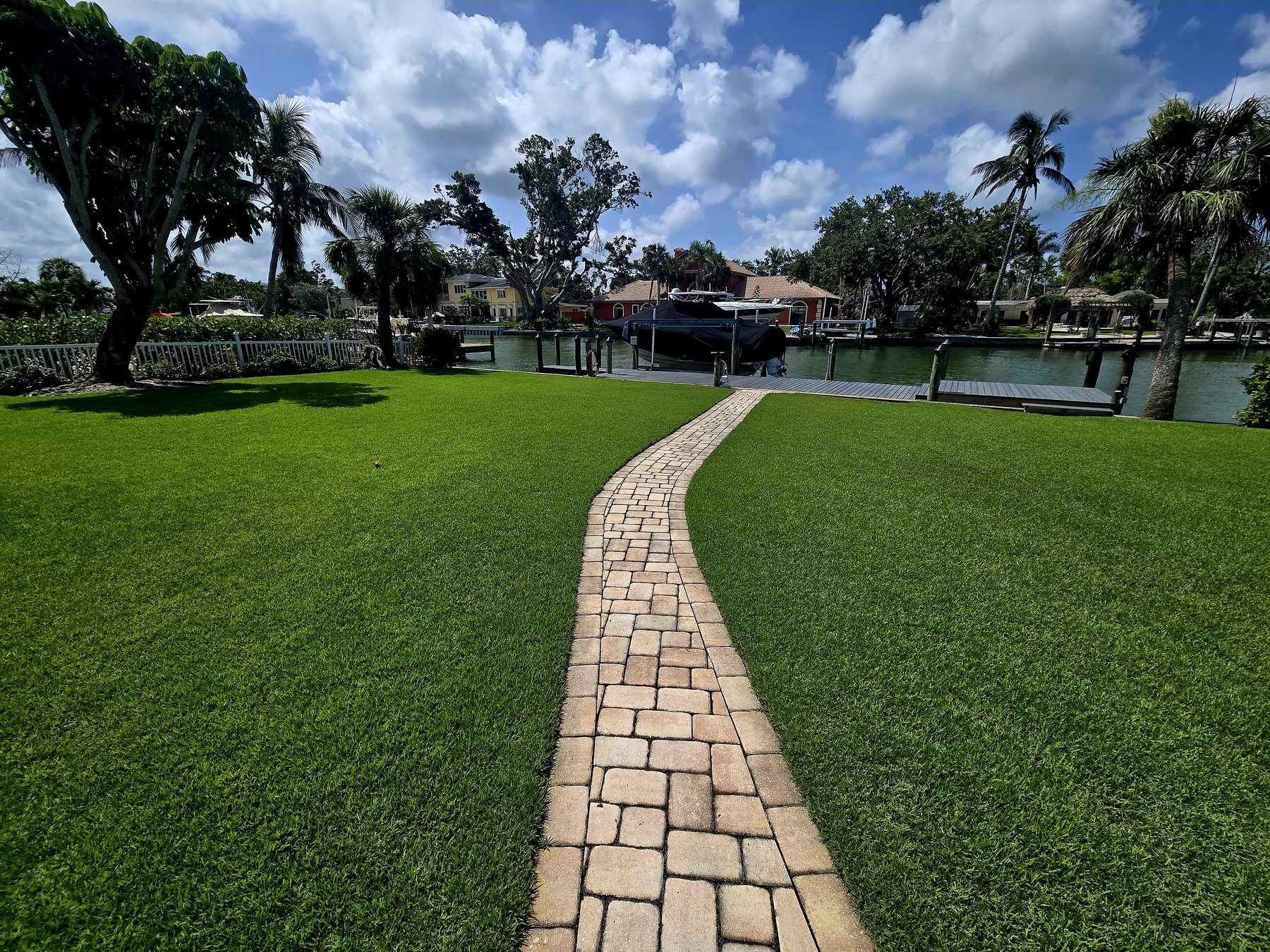 Waterfront lawn with a paver path to a dock